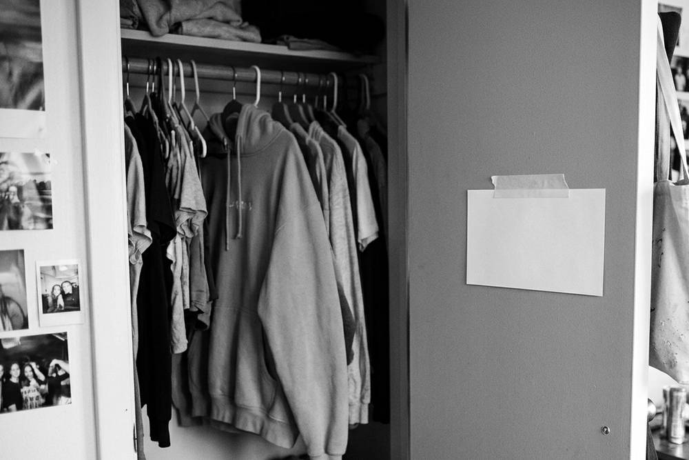 An index card taped inside a closet door, handwritten list of three items - 'walk + playlist', 'call Sam', 'dining hall with Maya, not desk'
